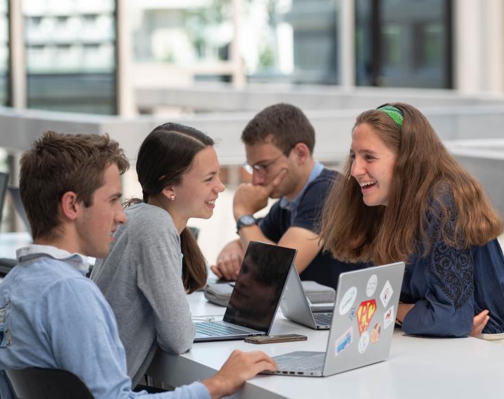 des étudiants en train de discuter devant leur ordinateur. Ils rigolent